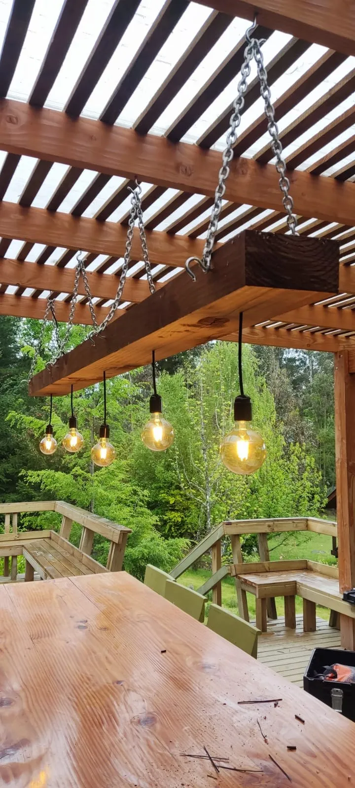 Luminaria tipo Edison colgante en pérgola de madera, instalación en parcela Araucanía