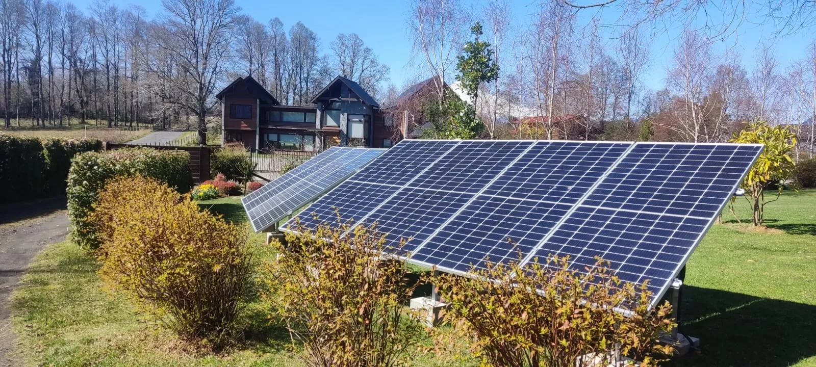 Gran sistema fotovoltaico en parcela con casa de campo al fondo, La Araucanía